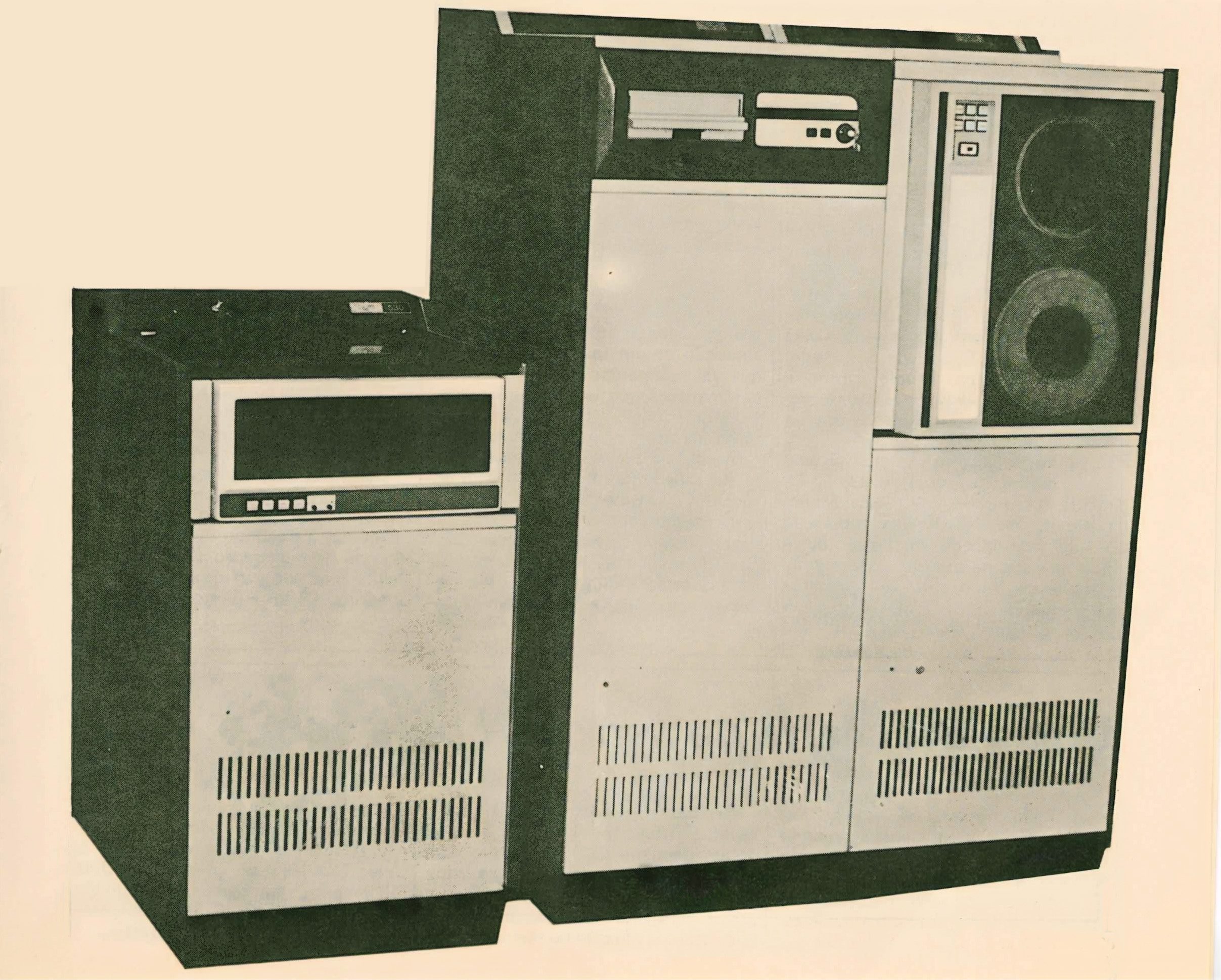 Foto de época, em tom envelhecido, do minicomputador Cobra 530, mostrando seus grandes gabinetes e a unidade de fita magnética de rolo.